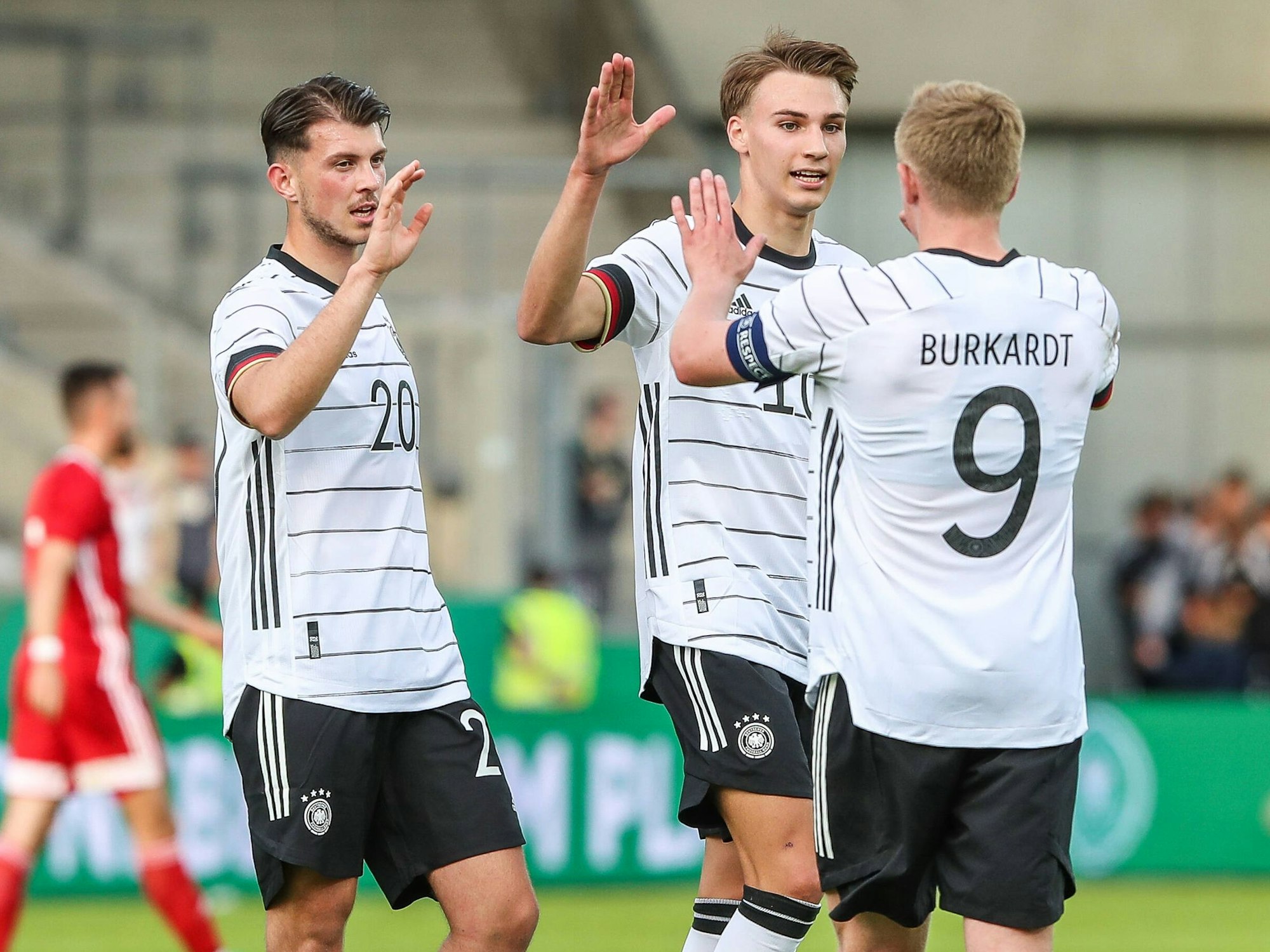 Lazar Samardzic, Tim Lemperle und Jonathan Burkhardt freuen sich nach dem Spielende über den Sieg gegen Ungarn.