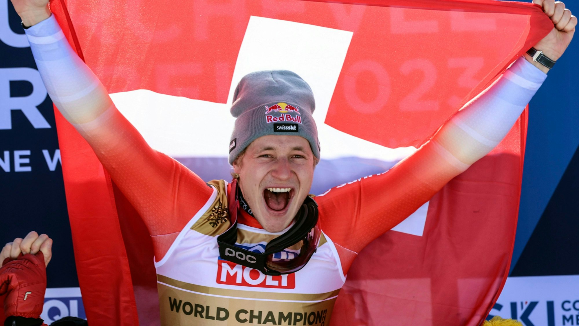 Marco Odermatt jubelt mit der Schweizer Flagge über seinen WM-Sieg in der Abfahrt.