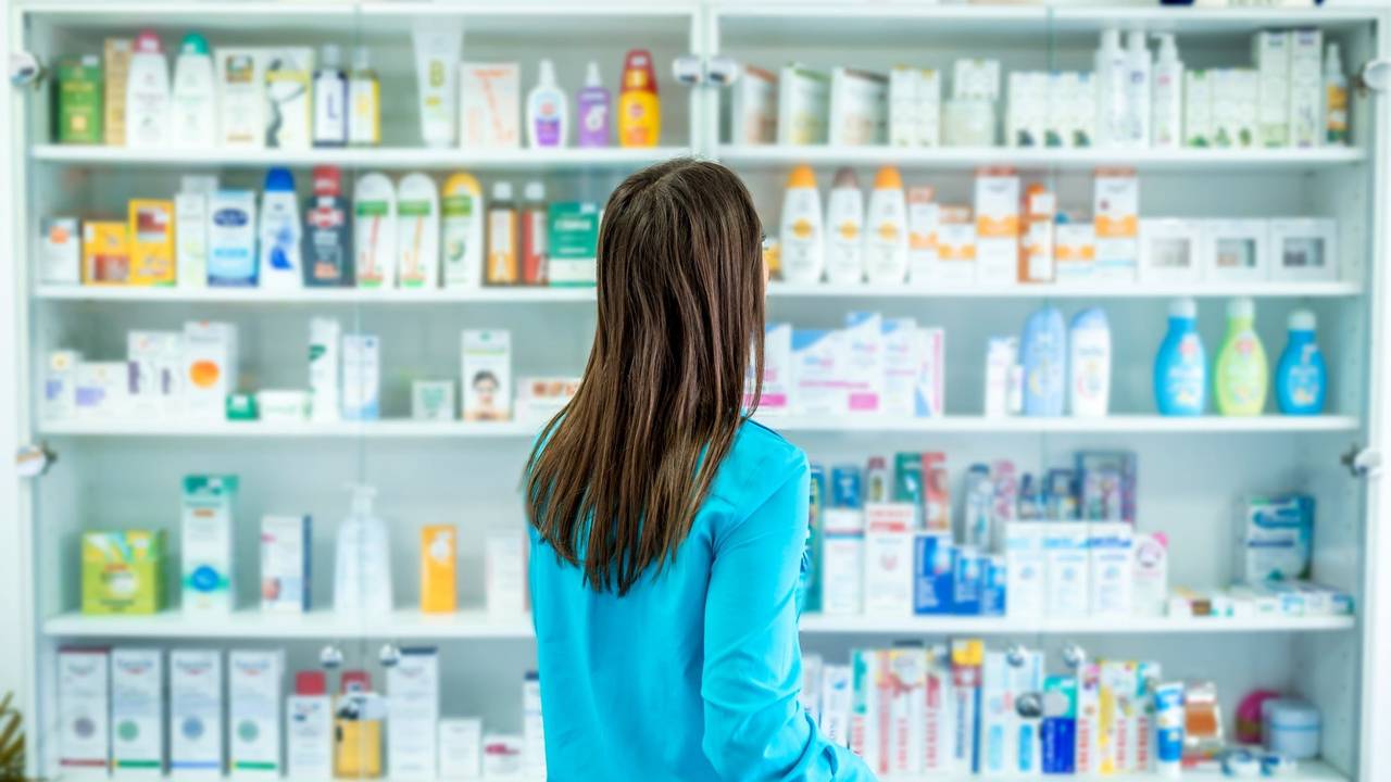 Frau steht vor Regal mit Drogerieprodukten