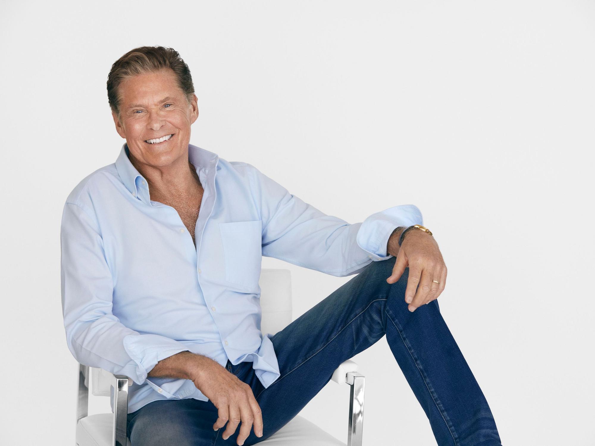 Der Popstar David Hasselhoff posiert auf einem Stuhl.