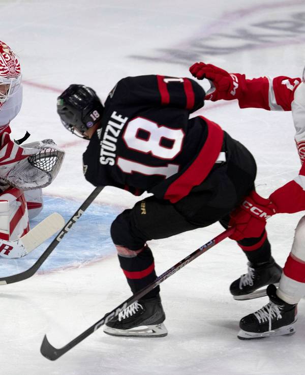Detroit Red Wings-Verteidiger Filip Hronek (r.) verfolgt Ottawa Senators-Linksaußen Tim Stützle (M.), der den Puck auf Red Wings-Torwart Ville Husso schießt