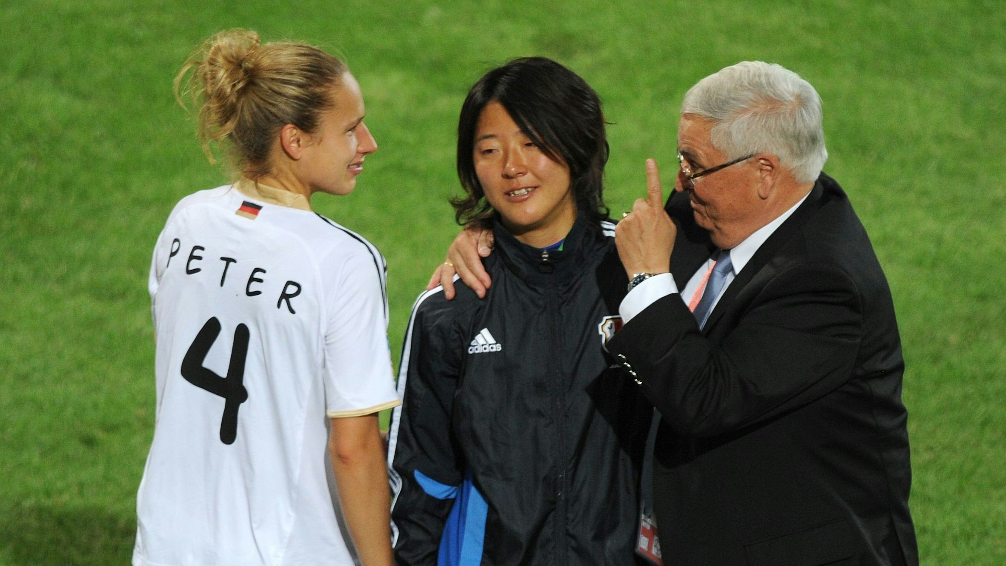 Theo Zwanziger beglückwünscht die Japanerin Yuki Nagasato zum Sieg. Daneben steht Babett Peter.