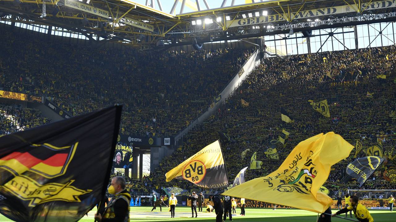 Ein Blick in den Signal-Iduna-Park beim BVB-Heimspiel gegen den VfL Wolfsburg. Auf dem Rasen werden mehrere Fahnen geschwenkt.