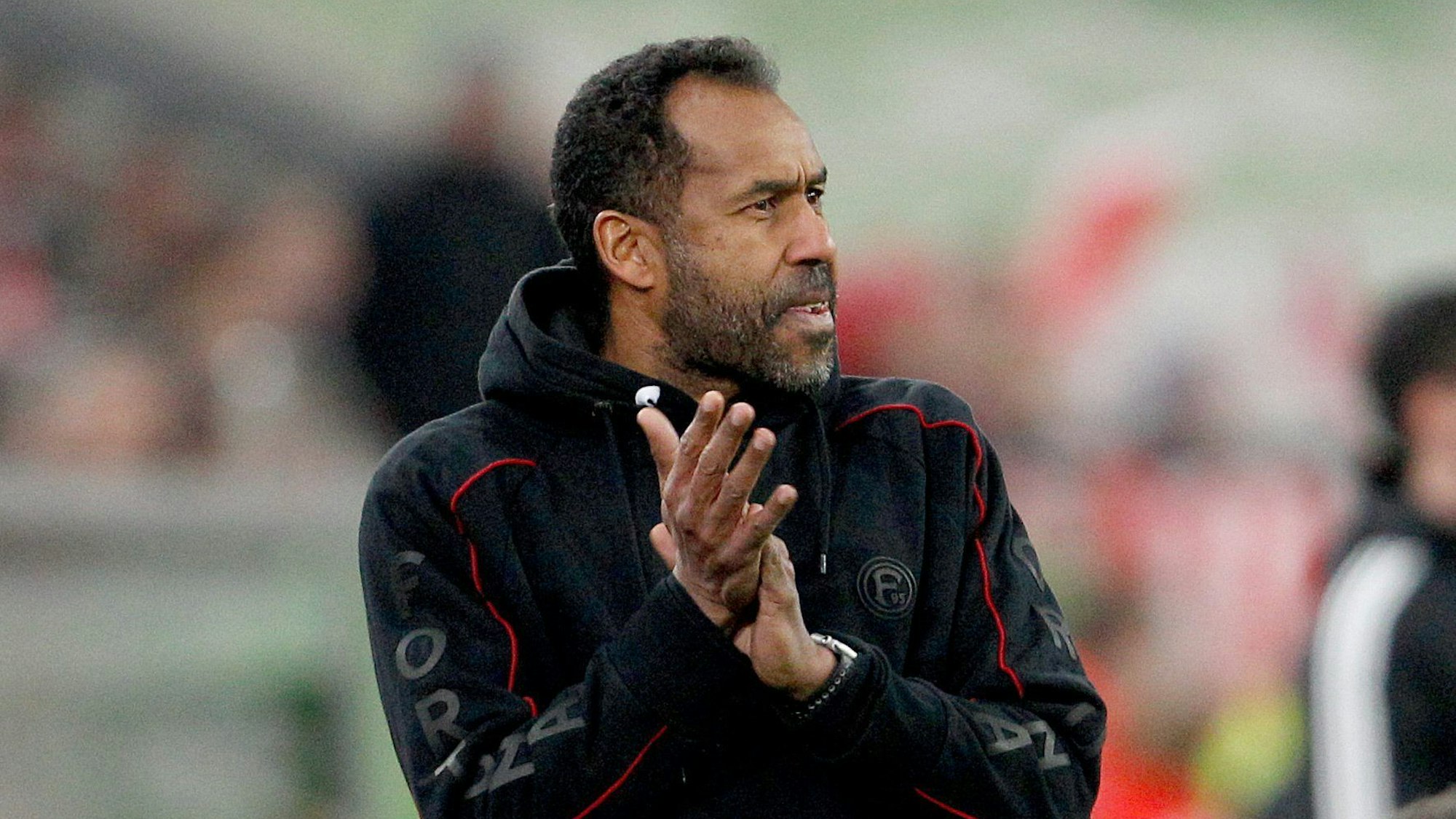 Düsseldorfs Trainer Daniel Thioune steht an der Seitenlinie und applaudiert seinen Spielern.