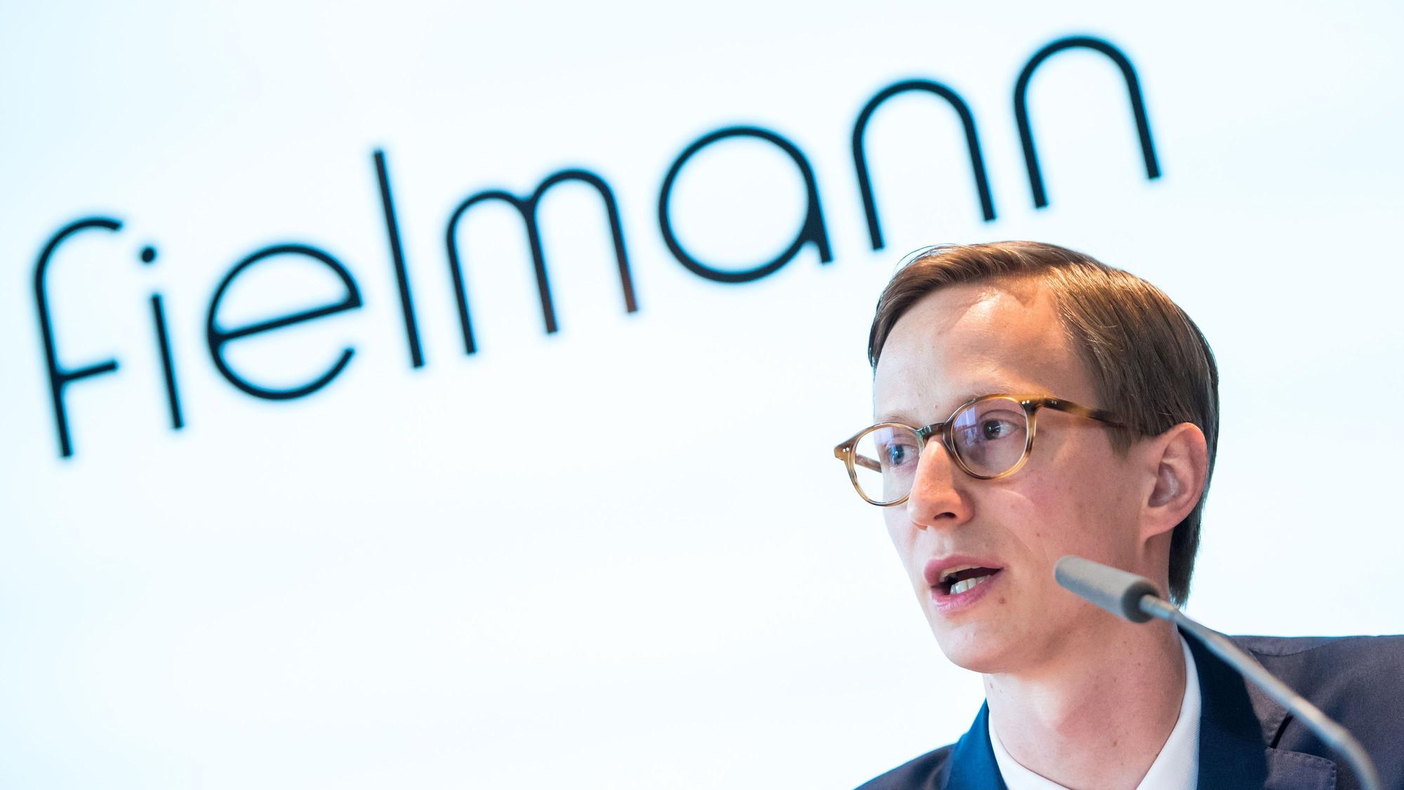 Marc Fielmann spricht bei der Bilanz-Pressekonferenz vor dem Logo des Unternehmens.