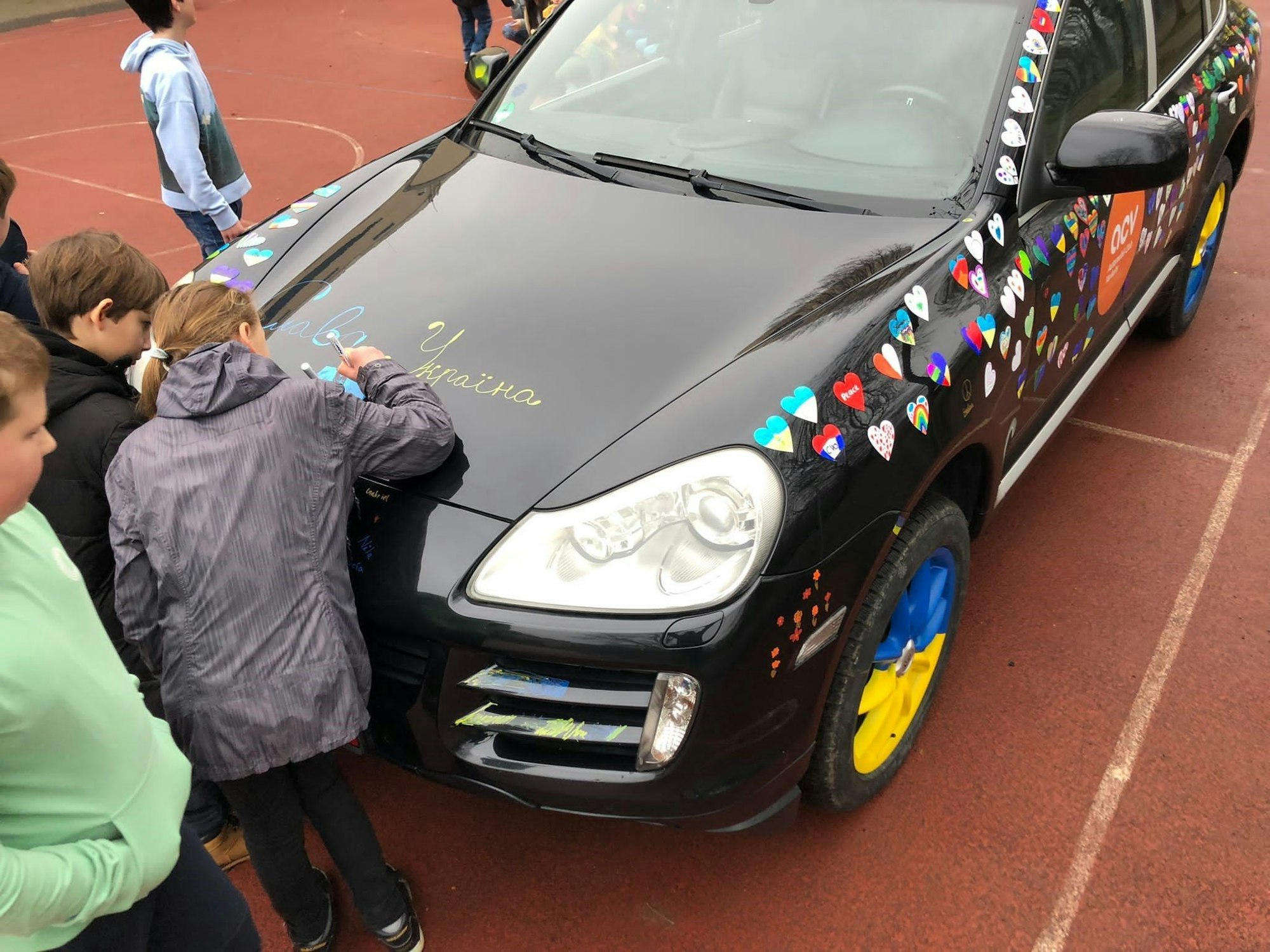 Die Kinder des Carl-von-Ossietzky-Gymnasiums in Bonn verzieren den Friedens-Porsche für die Ukraine.