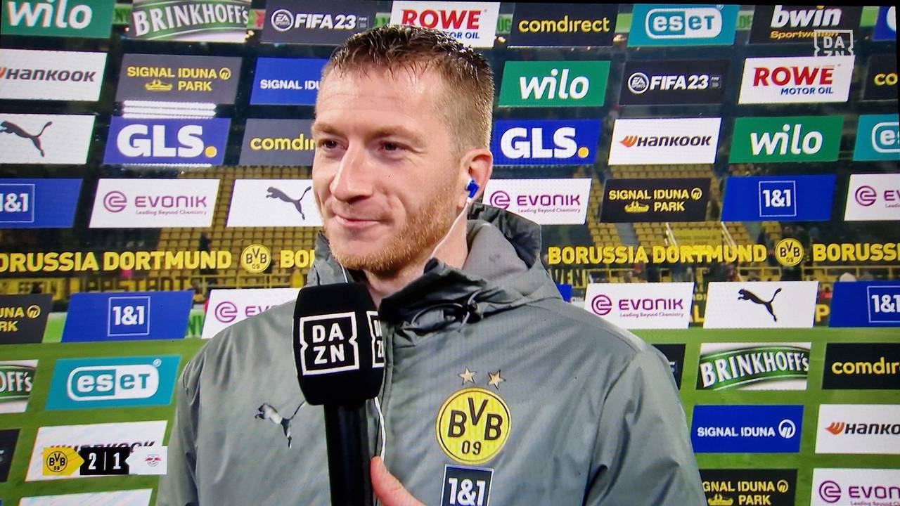 Marco Reus steht nach dem BVB-Sieg gegen RB Leipzig im DAZN-Interview vor einer Sponsorenwand.