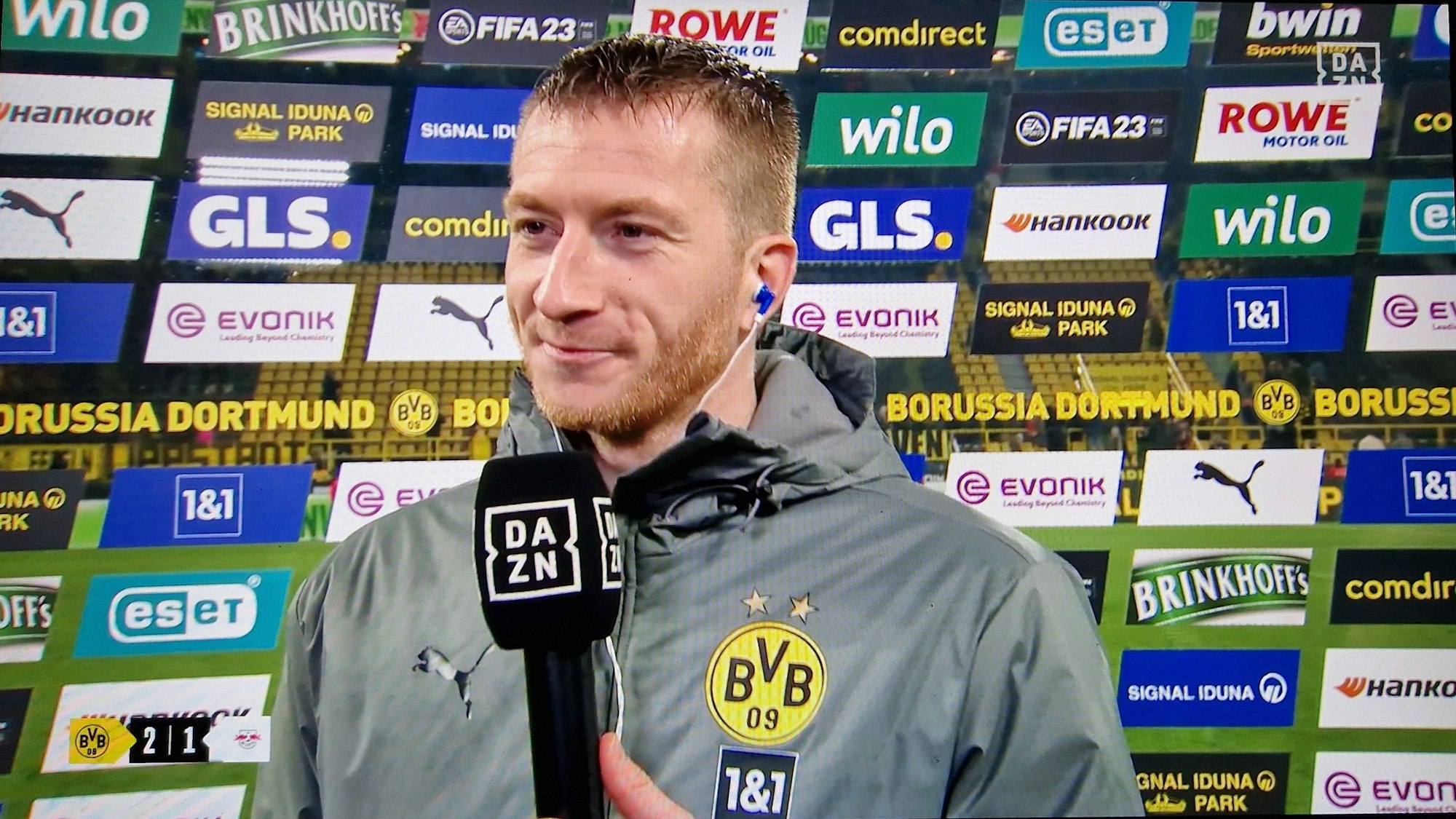 Marco Reus steht nach dem BVB-Sieg gegen RB Leipzig im DAZN-Interview vor einer Sponsorenwand.