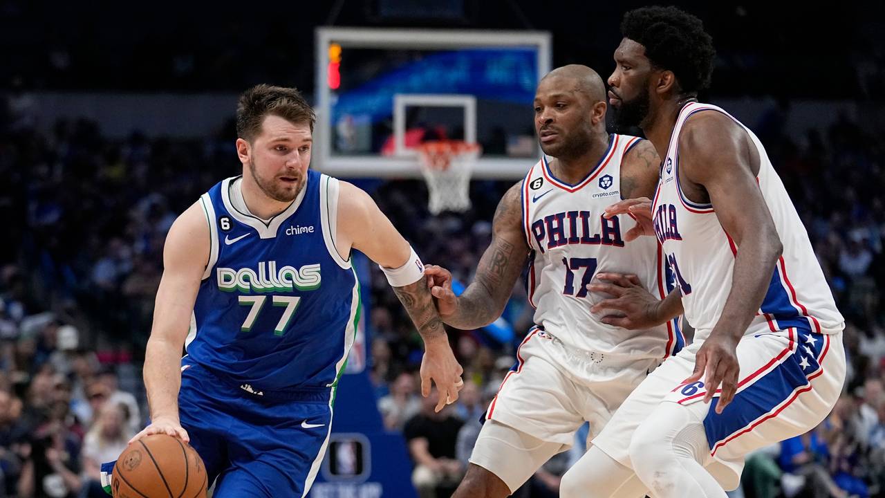 Mavericks Luka Doncic (l.) mit dem Ball versucht an Joel Embiid (r.) und P.J. Tucker vorbeizukommen.
