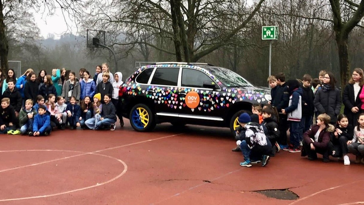 Rund 100 Schüler der fünften Klasse des Carl-von-Ossietzky-Gymnasium  stolz am geschmückten Wagen.