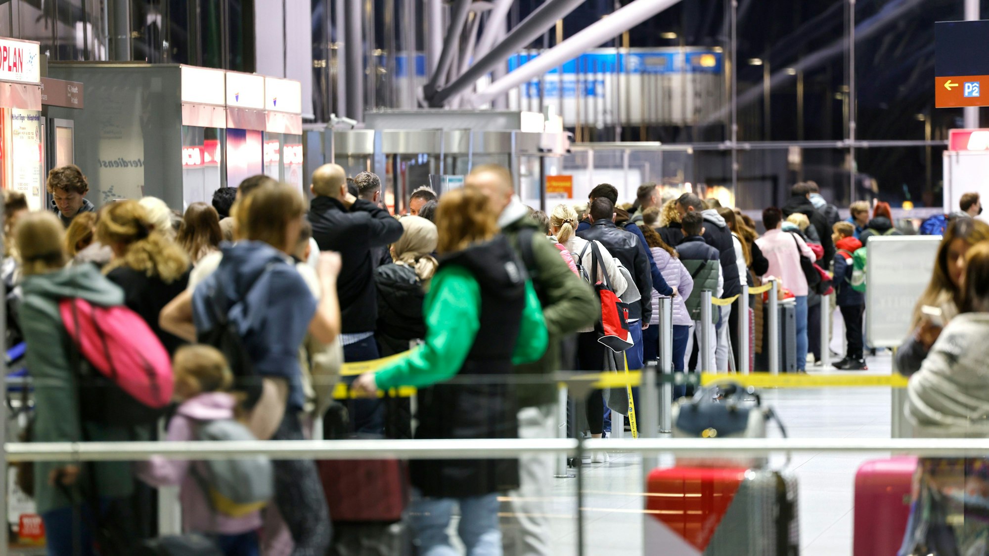 Reisende am Flughafen Köln/Bonn stehen in der Abflughalle an den Schaltern in Schlangen.