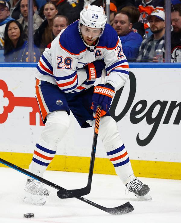 Leon Draisaitl (29), Center der Edmonton Oilers, schiebt den Puck an Dylan Cozens (24), Center der Buffalo Sabres, vorbei, vor das Netz.