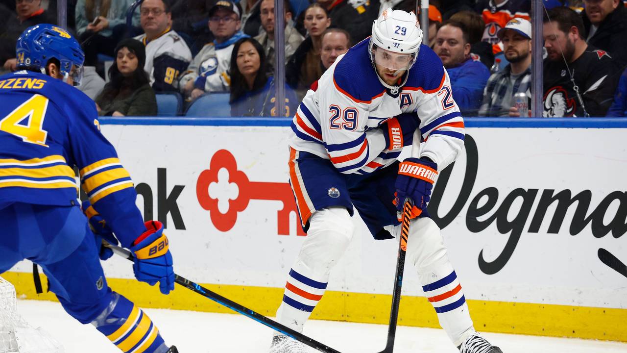 Leon Draisaitl (29), Center der Edmonton Oilers, schiebt den Puck an Dylan Cozens (24), Center der Buffalo Sabres, vorbei, vor das Netz.