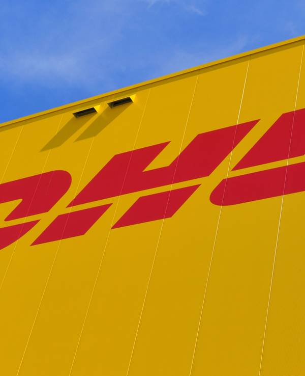 Das Logo des Paketdienstes DHL der Deutschen Post auf der Fassade eines Paketzentrums im Juni 2020 in Ludwigsfelde.