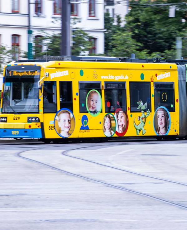 Das Symbolfoto aus dem Jahr 2020 zeigt eine bunte Straßenbahn und einen roten Bus.