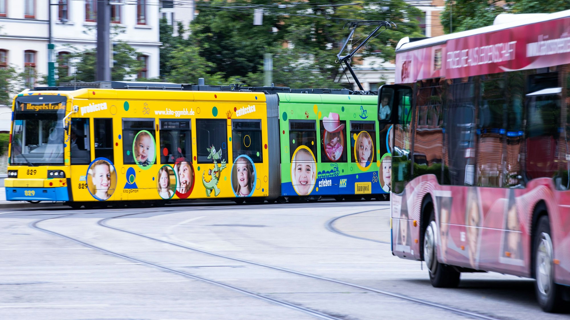 Das Symbolfoto aus dem Jahr 2020 zeigt eine bunte Straßenbahn und einen roten Bus.