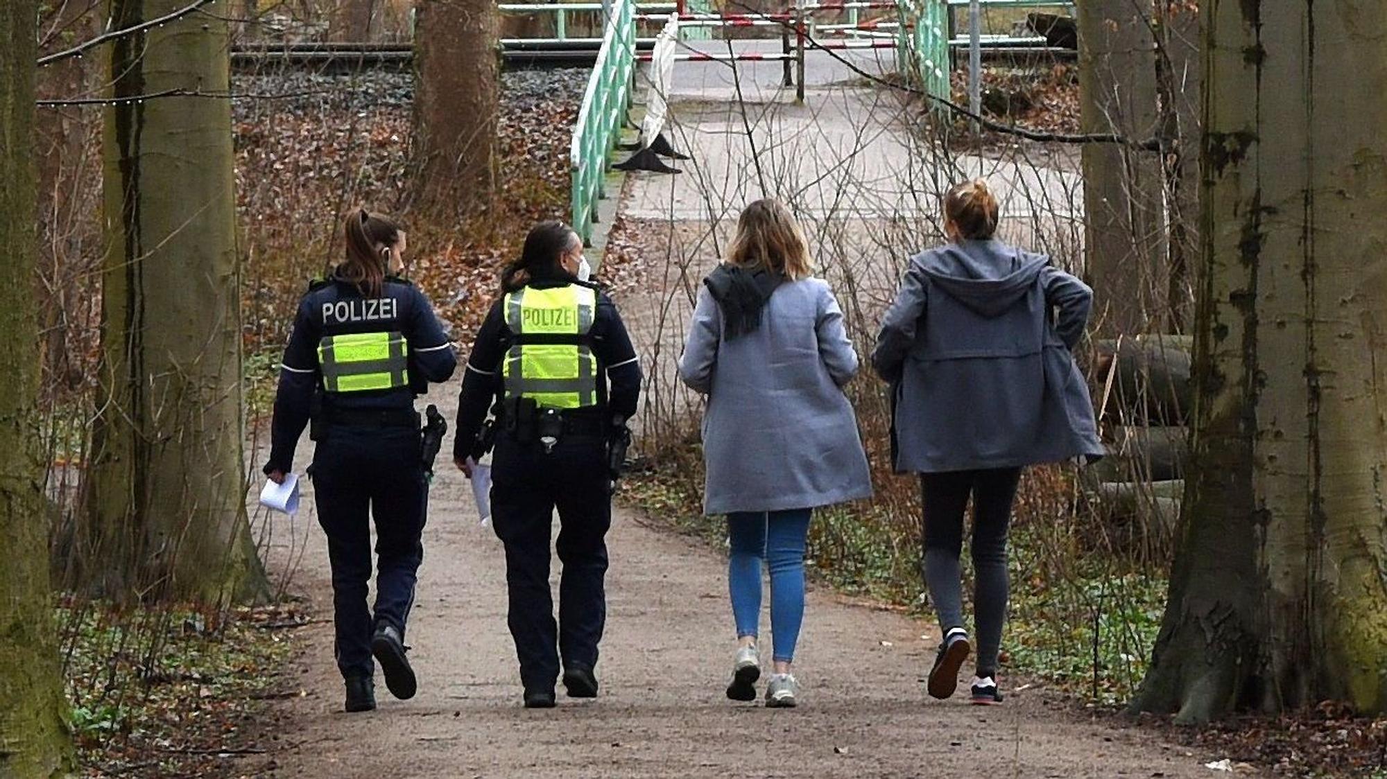 Polizeibeamte suchen im Stadtwald nach Augenzeugen.