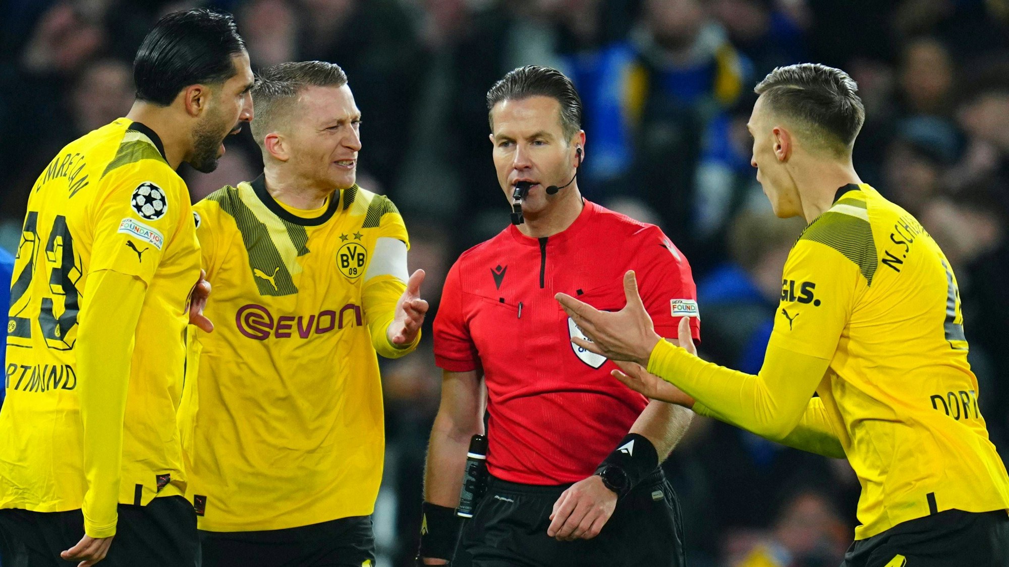 Emre Can, Marco Reus und Nico Schlotterbeck diskutieren mit Schiedsrichter Danny Makkelie.