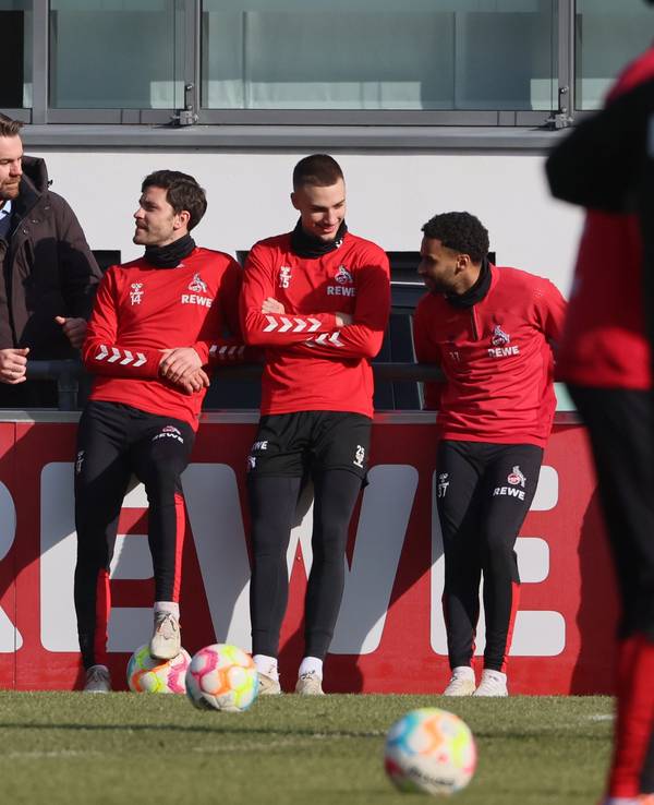 Sargis Adayan unterhält sich beim Training des 1. FC Köln an der Bande mit Thomas Kessler, Jonas Hector, Tim Lemperle und Linton Maina.