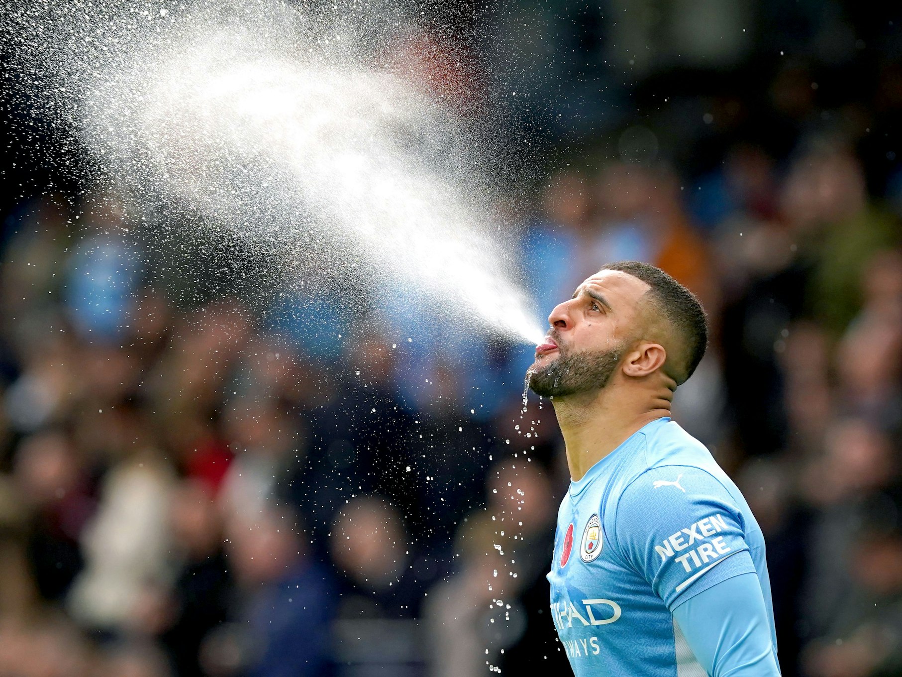 Manchester Citys Kyle Walker spuckt vor Spielbeginn Wasser auf das Spielfeld.
