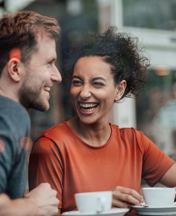 Mann und Frau sitzen im Cafe und lachen gemeinsam
