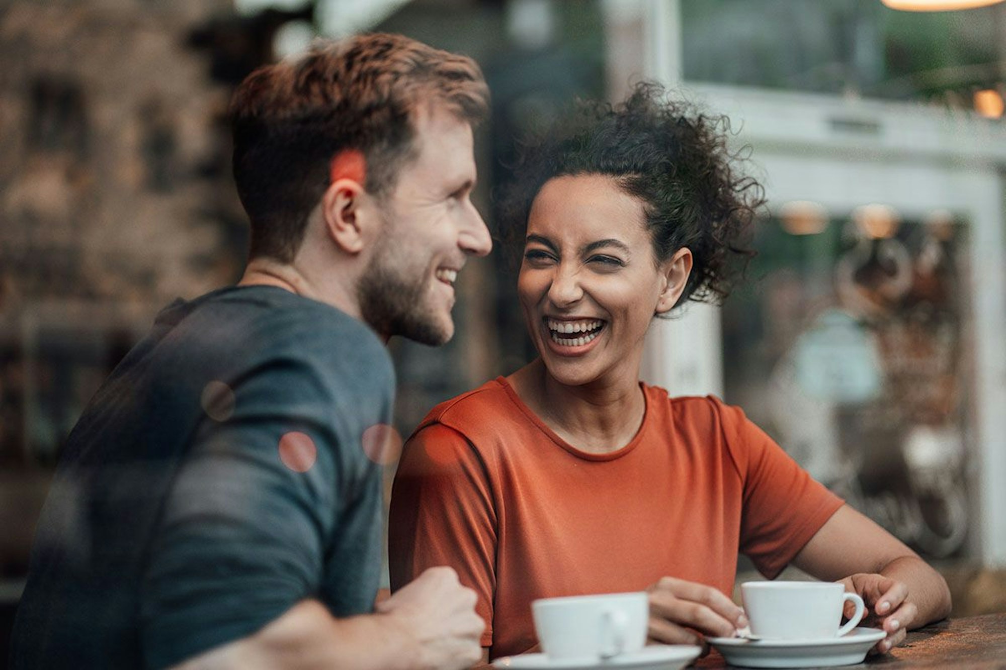 Mann und Frau sitzen im Cafe und lachen gemeinsam