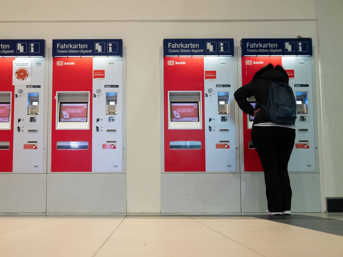 Eine Frau steht im Hauptbahnhof an einem Fahrkartenautomaten.