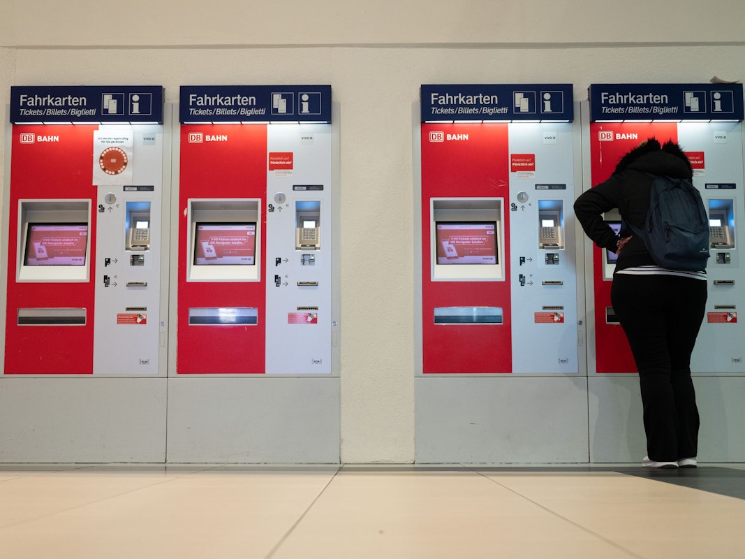 Eine Frau steht im Hauptbahnhof an einem Fahrkartenautomaten.