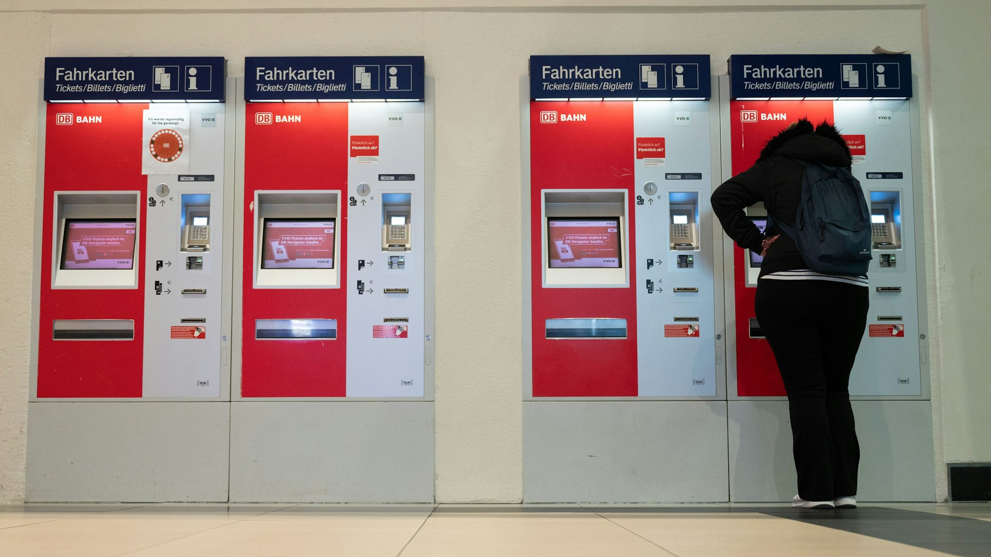 Eine Frau steht im Hauptbahnhof an einem Fahrkartenautomaten.