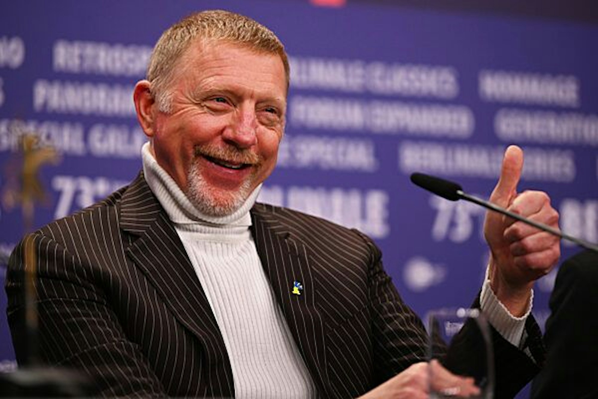 Boris Becker lächelt in die Kameras.