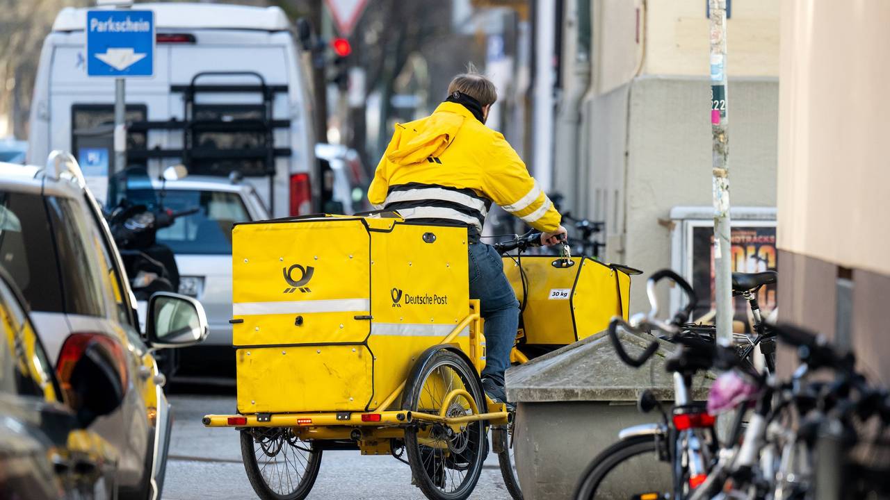 Das undatierte Foto zeigt einen Mitarbeiter der Deutschen Post. Er trägt Briefe mit einem gelben Lastenfahrrad aus.