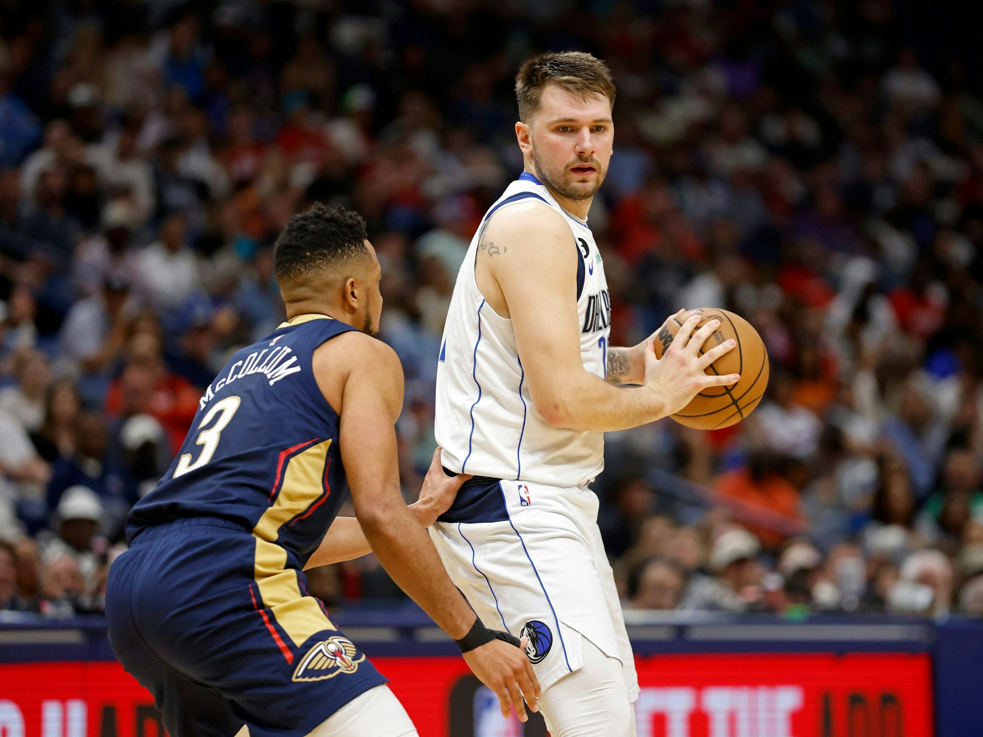 Dallas Mavericks-Guard Luka Doncic (77) wird von New Orleans Pelicans-Guard CJ McCollum (3) verteidigt.
