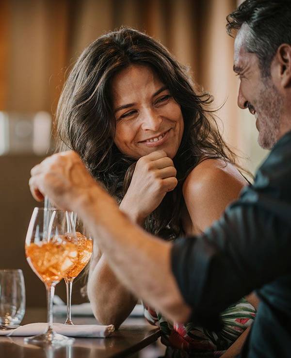 Glückliche Frau und Mann in einer Bar mit Getränk