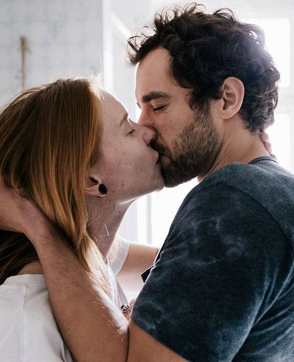 Frau und Mann küssen sich im Badezimmer
