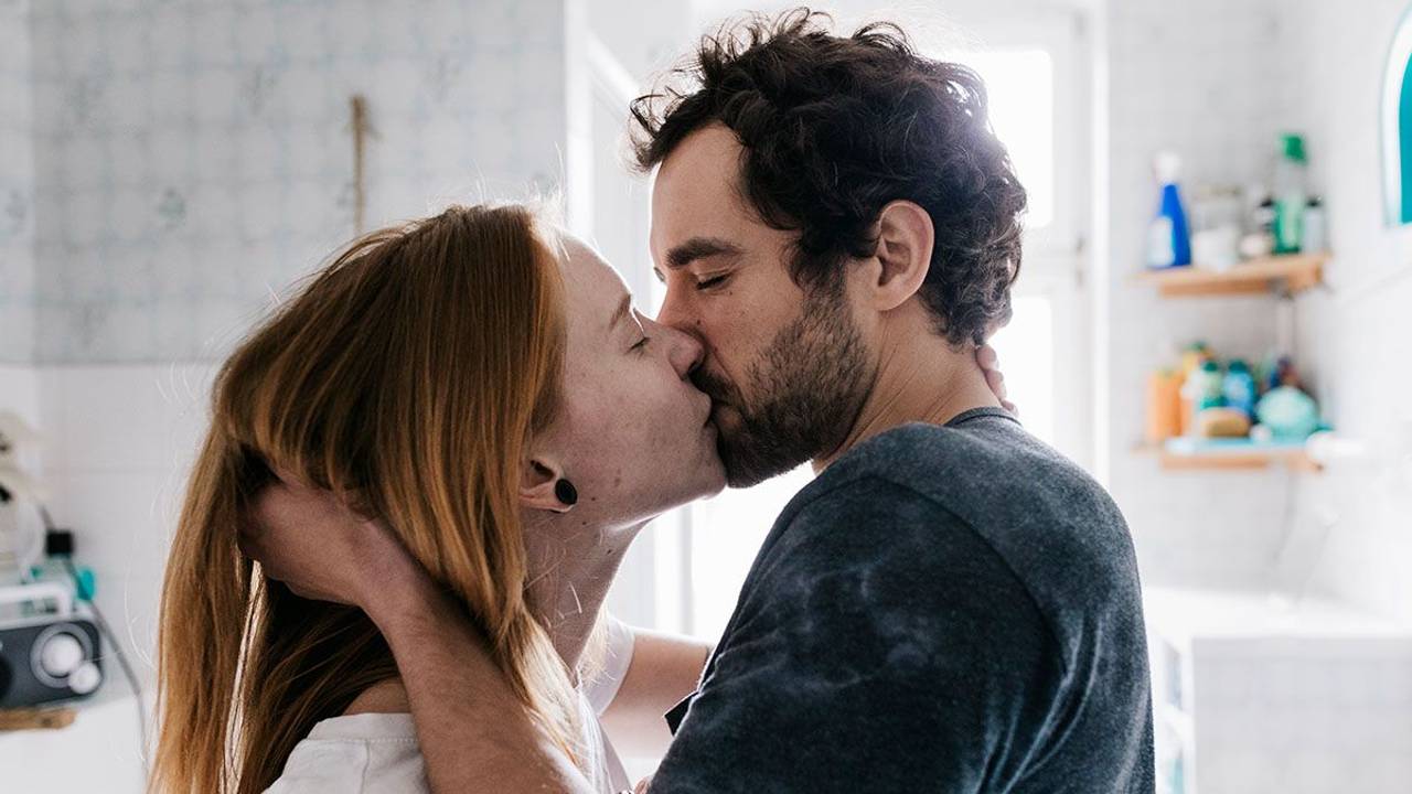 Frau und Mann küssen sich im Badezimmer