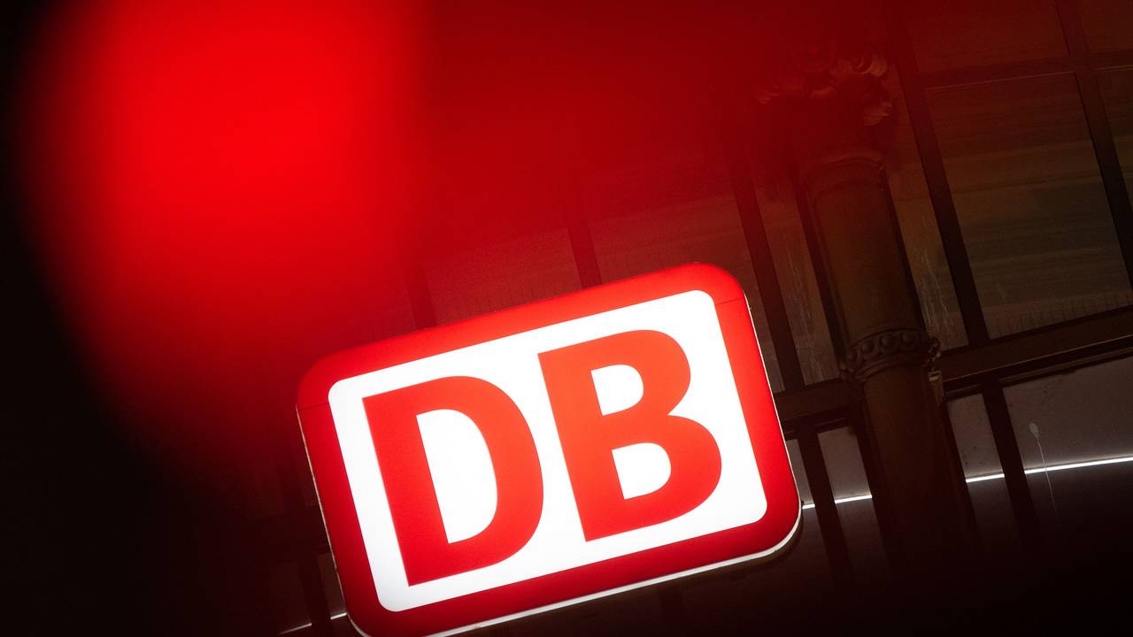 Das Logo der Deutschen Bahn leuchtet am Hauptbahnhof hinter einer Ampel.