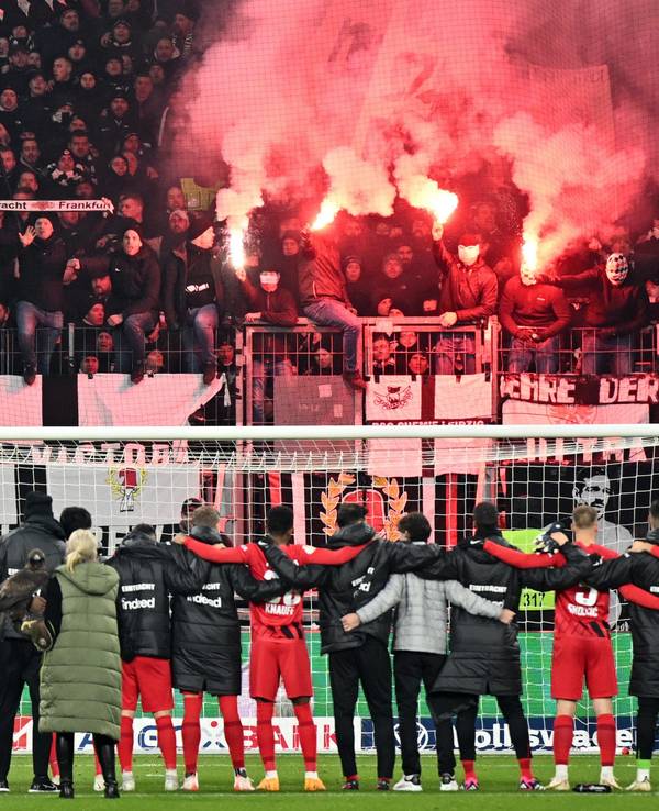 Die Spieler von Eintracht Frankfurt jubeln mit ihren Fans in der Kurve.