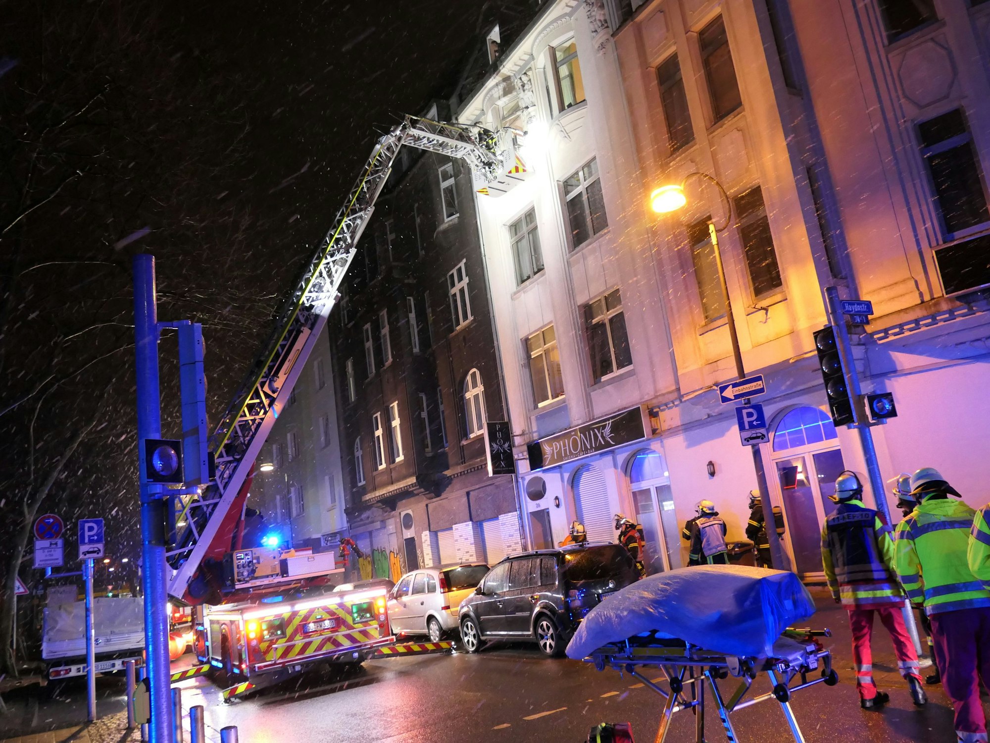 Auf dem Bild sieht man Einsatzkräfte der Feuerwehr vor einem Haus in Dortmund. Eine Drehleiter wird eingesetzt.
