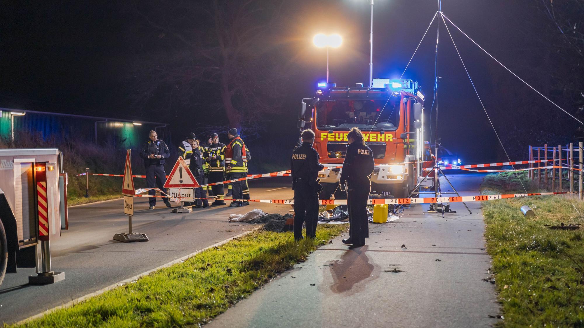 Der Bereich um den Gully ist abgesperrt, ein Feuerwehrwagen sowie mehrere Einsatzkräfte sind vor Ort.