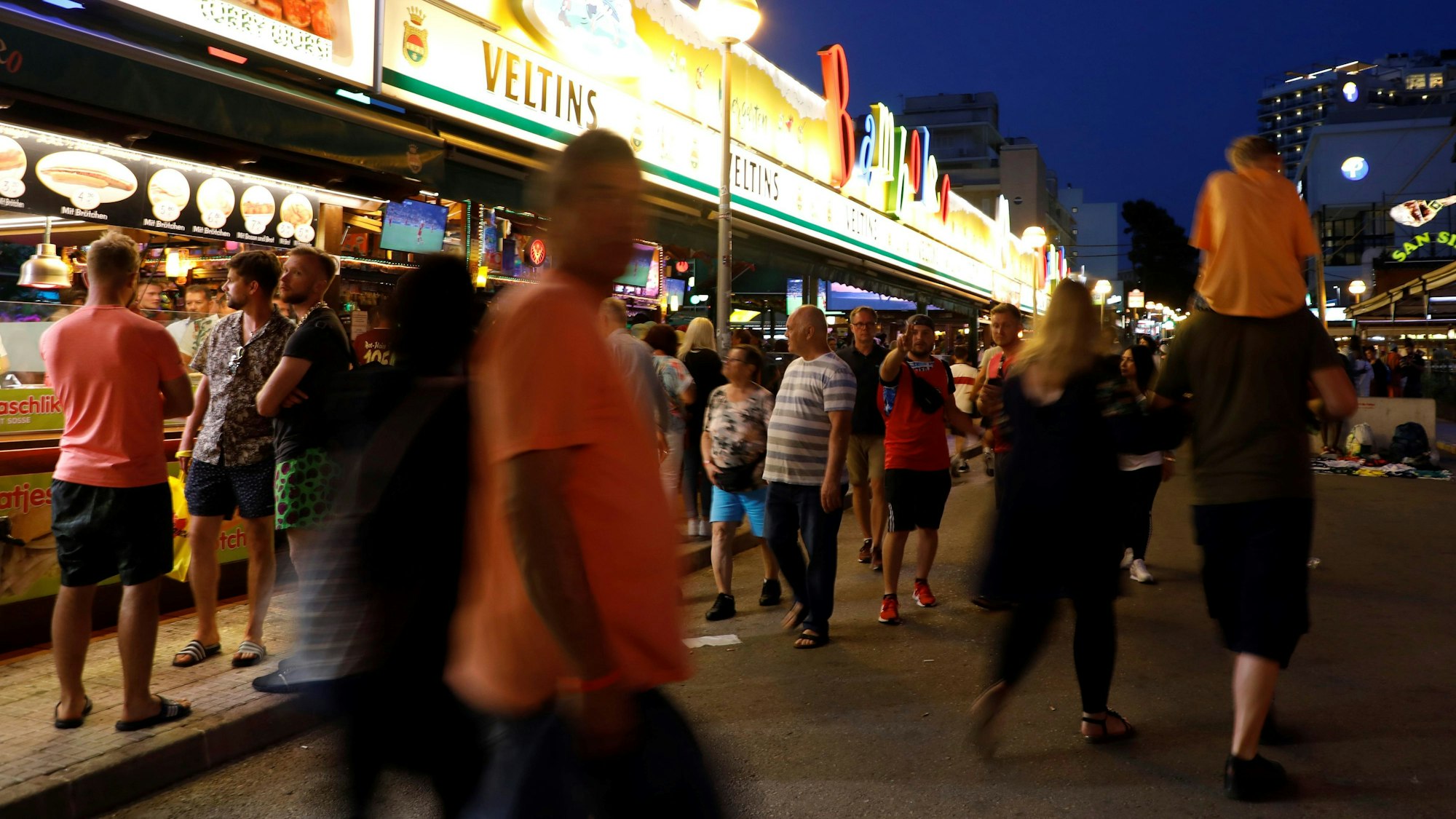 Menschen gehen an der Bar Bamboleo in der Bierstraße am Ballermann vorbei.