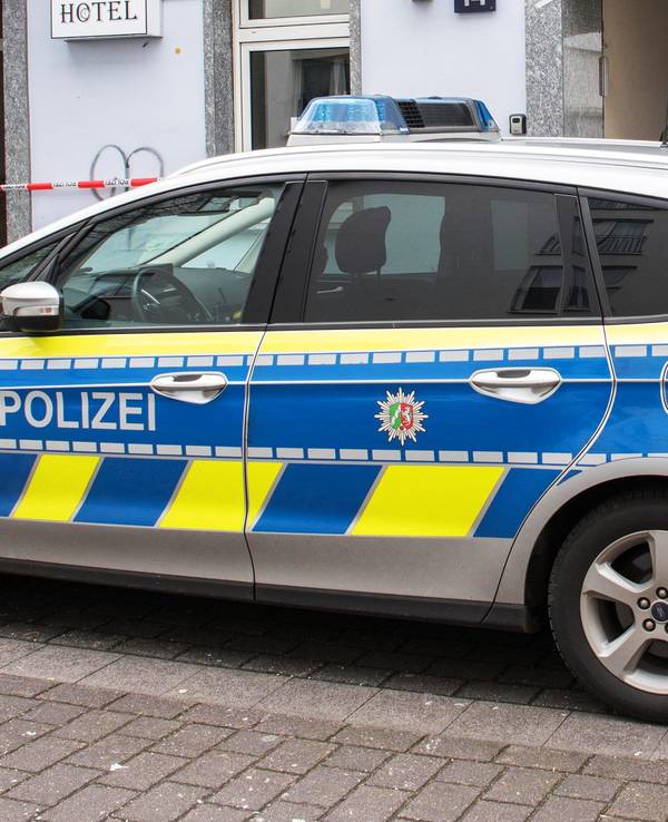 Ein Polizeiauto steht vor einem Hotel.
