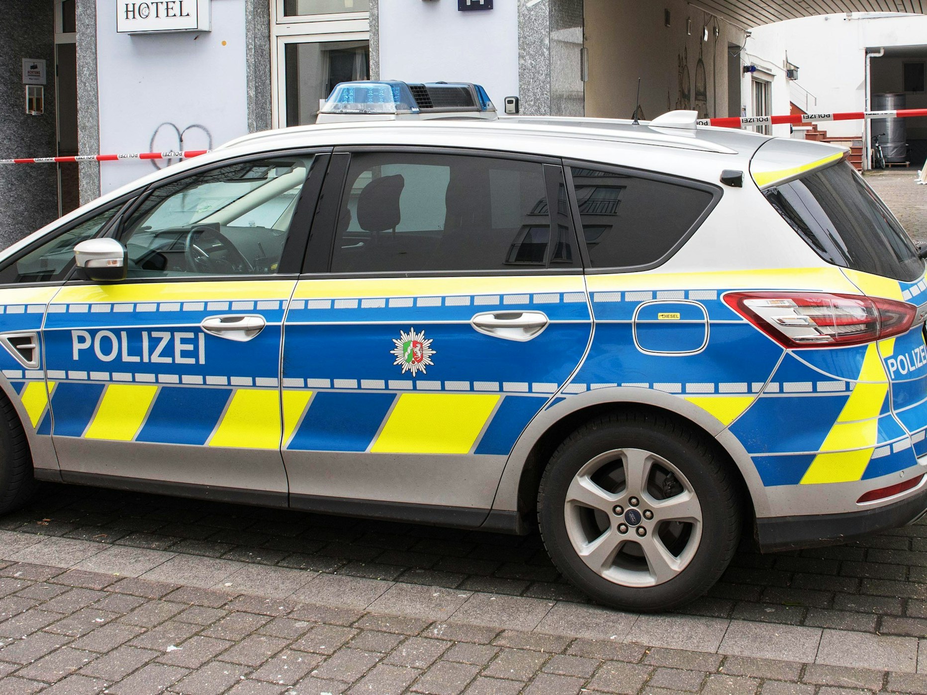 Ein Polizeiauto steht vor einem Hotel.