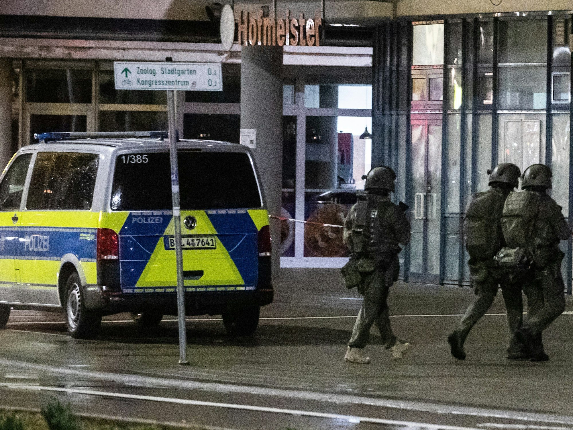 Auf dem Bild sieht man Polizisten, die zu einer Apotheke in Karlsruhe gehen. Sie gehören zum Spezialkommando der Polizei.