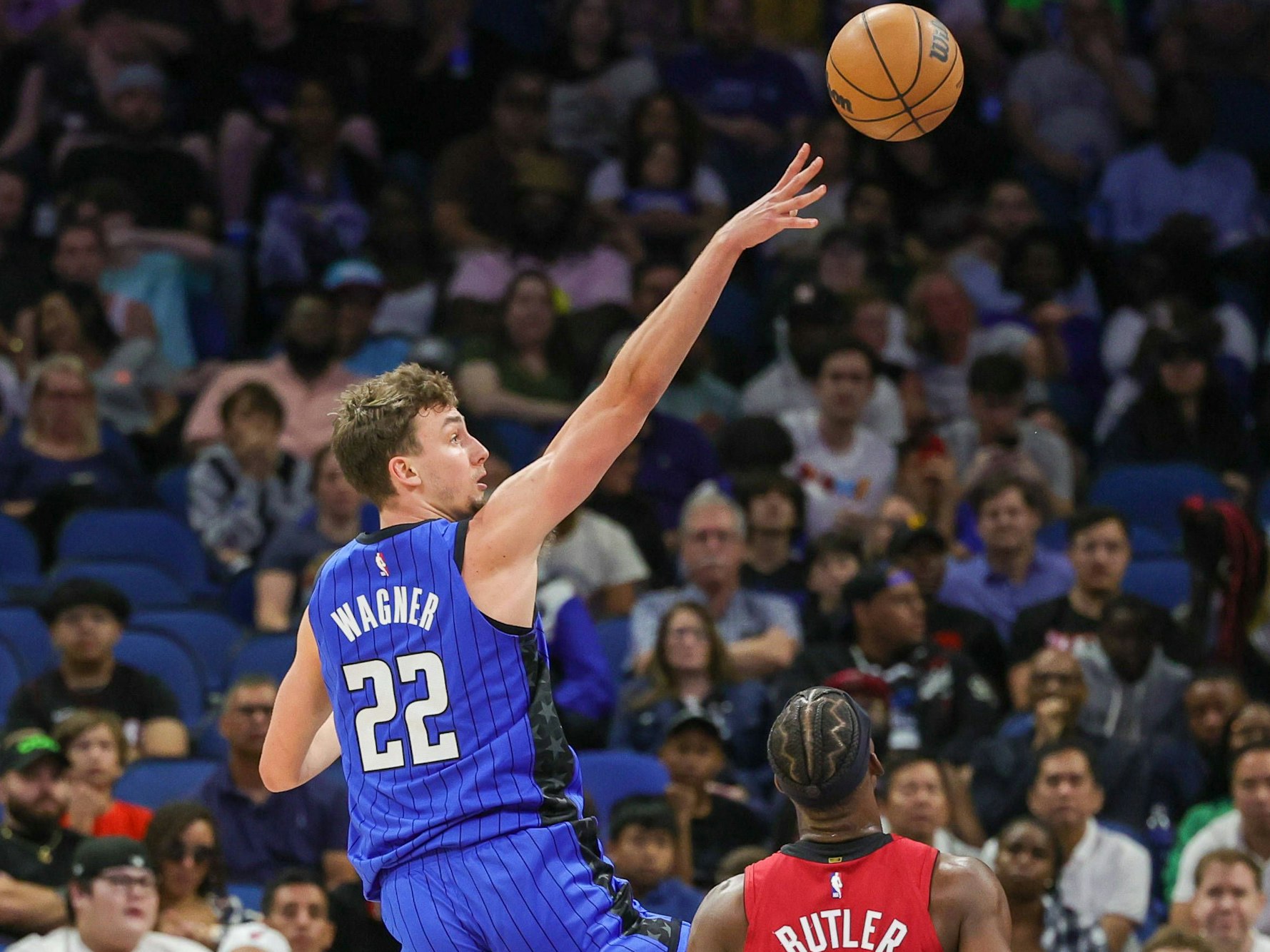 Franz Wagner wirft den Ball. Im Vordergrund schaut Jimmy Butler zu.