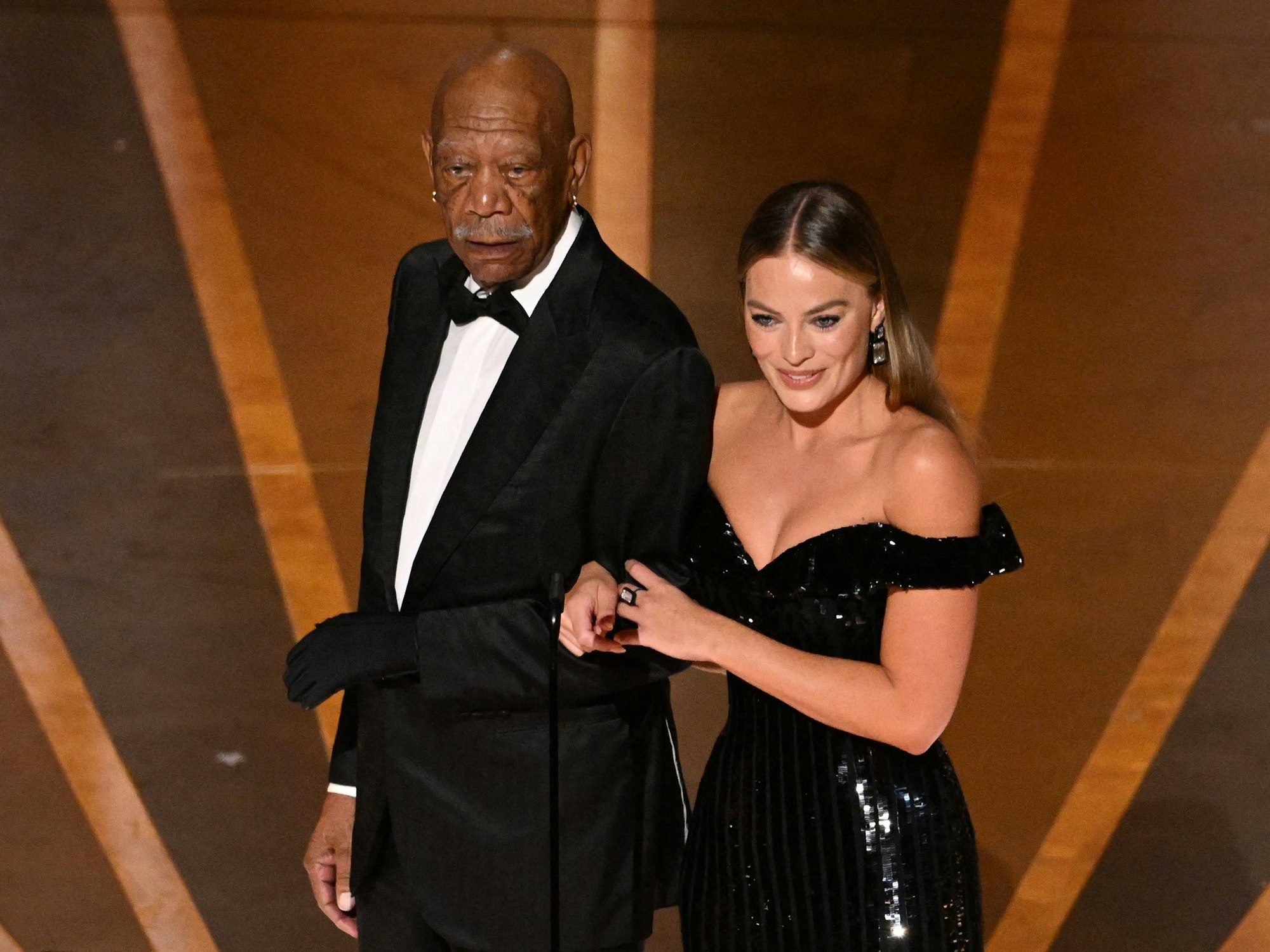US-Schauspieler Morgan Freeman stand mit einem einzelnen schwarzen Handschuh an seiner linken Hand auf der Bühne, auf unserem Foto geleitet er US-Schauspielerin Margot Robbie in den Saal.