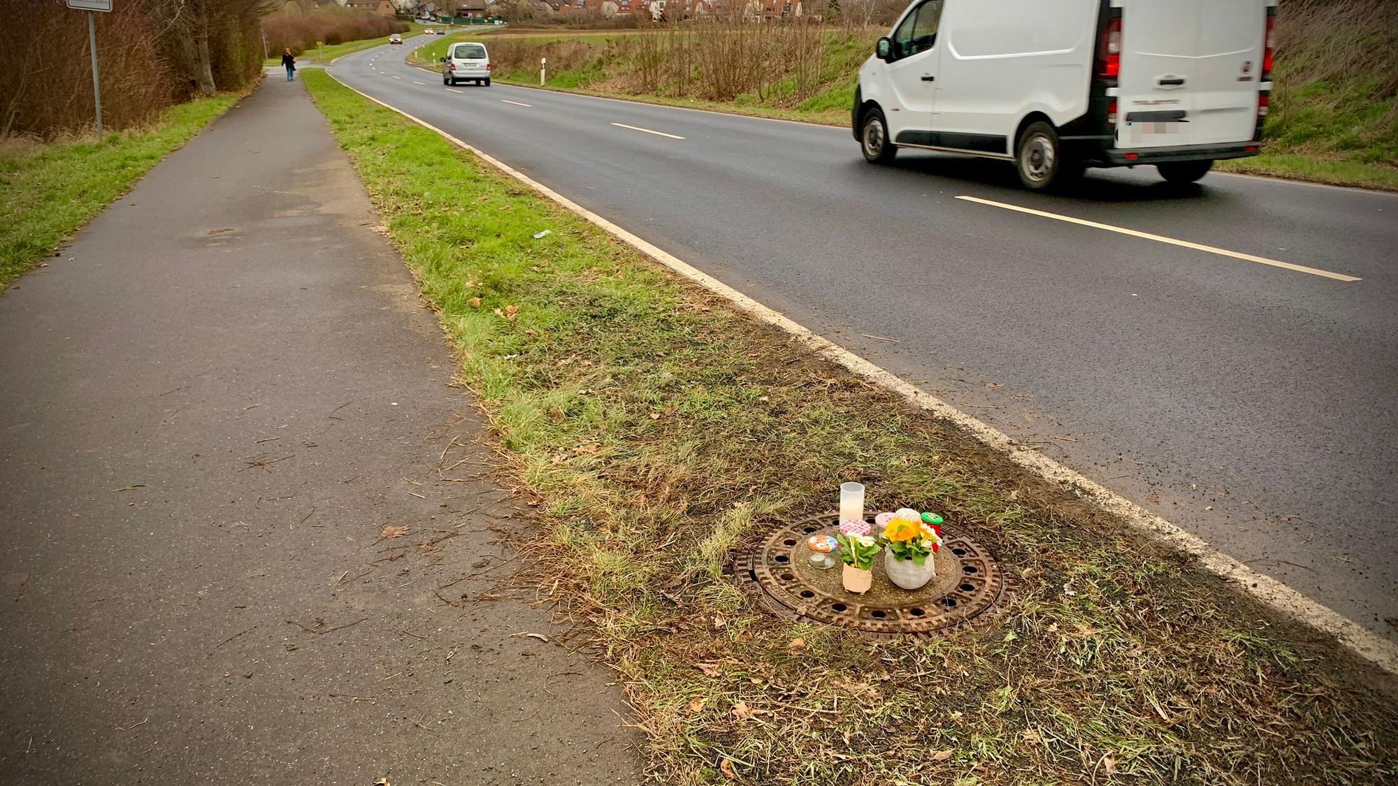 Kerzen und Blumen stehen auf dem Gullydeckel, in dem in der Nacht von Samstag auf Sonntahg eine Leiche gefunden wurde.