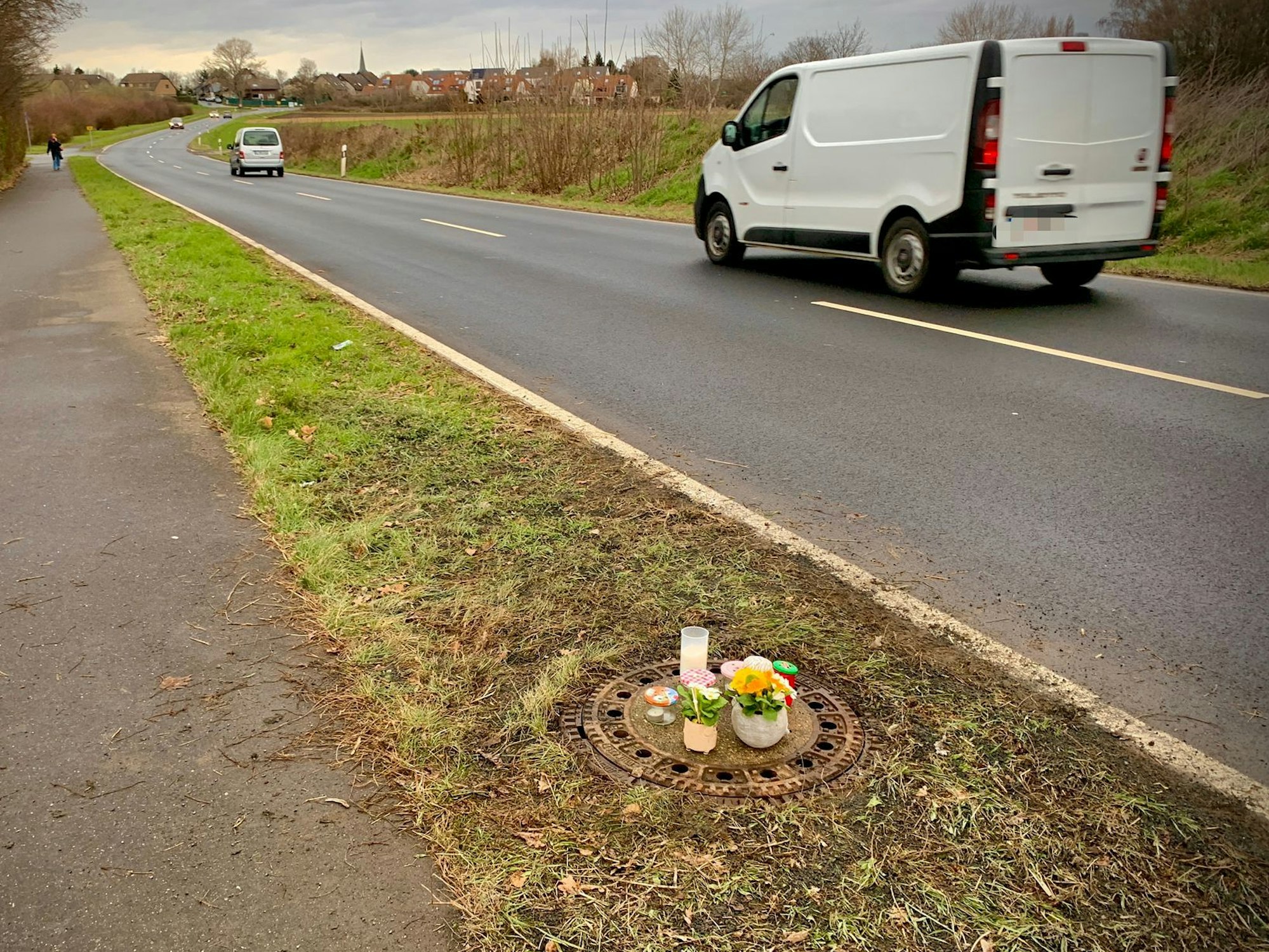 Kerzen und Blumen stehen auf dem Gullydeckel, in dem in der Nacht von Samstag auf Sonntahg eine Leiche gefunden wurde.