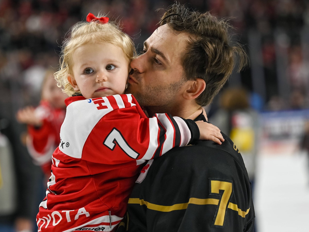 Nick Bailen (Kölner Haie) mit seiner Tochter auf dem Arm bei der Ehrenrunde gegen die Bietigheim Steelers.