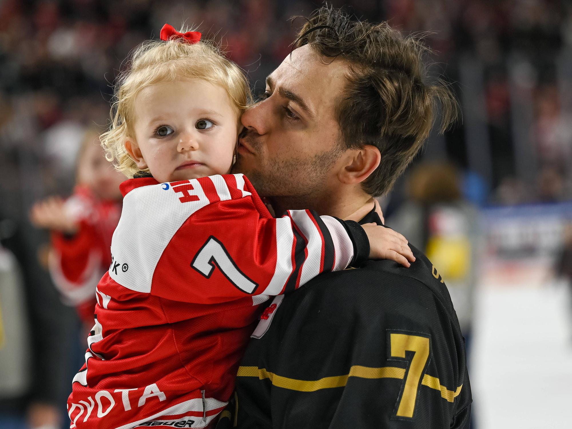 Nick Bailen (Kölner Haie) mit seiner Tochter auf dem Arm bei der Ehrenrunde gegen die Bietigheim Steelers.