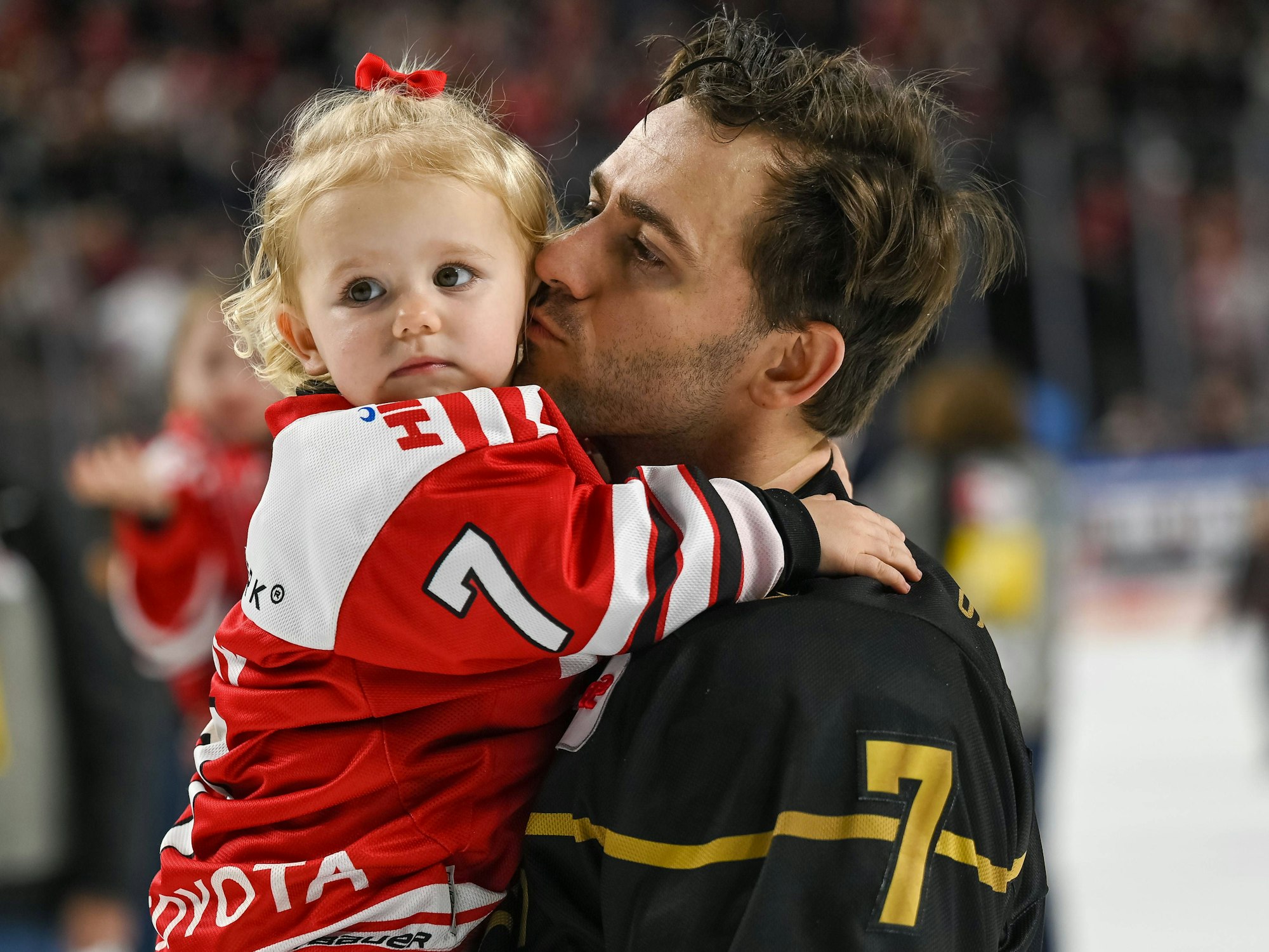 Nick Bailen (Kölner Haie) mit seiner Tochter auf dem Arm bei der Ehrenrunde gegen die Bietigheim Steelers.